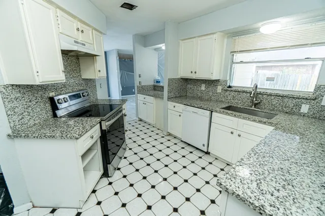 a kitchen with a sink stove and cabinets