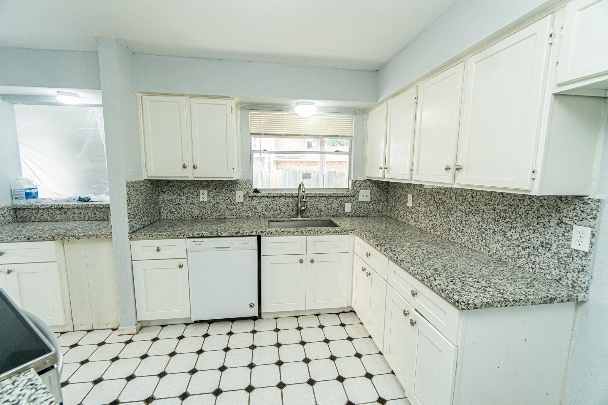 10903 Nobility Drive Houston, TX 77099 - Photo 4 of 12 a kitchen with granite countertop white cabinets white appliances with a sink and a window