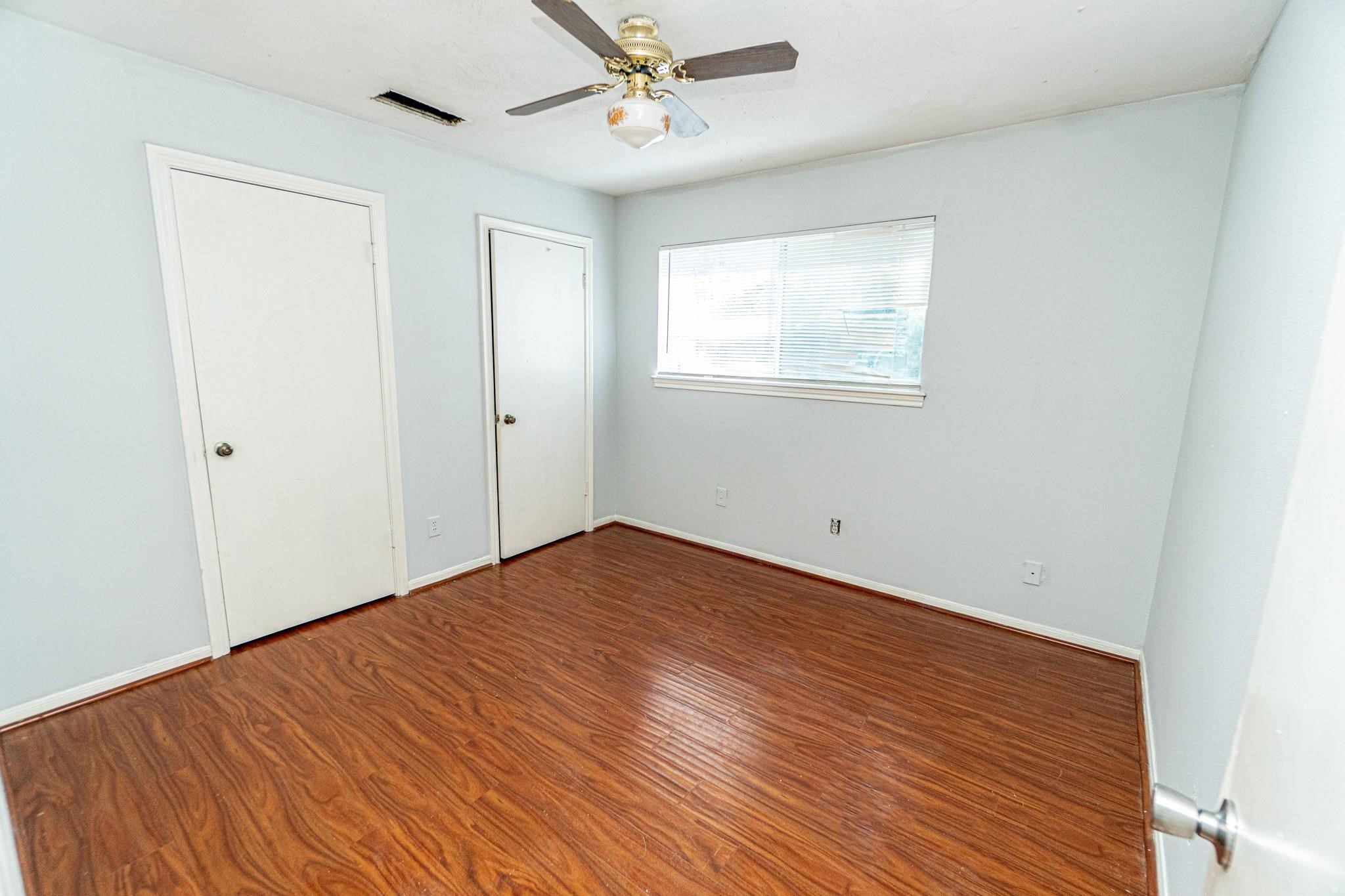 10903 Nobility Drive Houston, TX 77099 - Photo 8 of 12 an empty room with wooden floor ceiling fan and windows