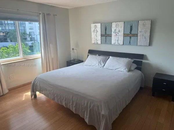 a large bed sitting in a bedroom next to a window