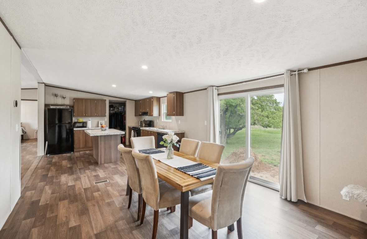 989 Ferguson Loop Dale Dale, TX 78616 - Photo 12 of 21 Dining space with dark wood finished floors, recessed lighting, a textured ceiling, and lofted ceiling