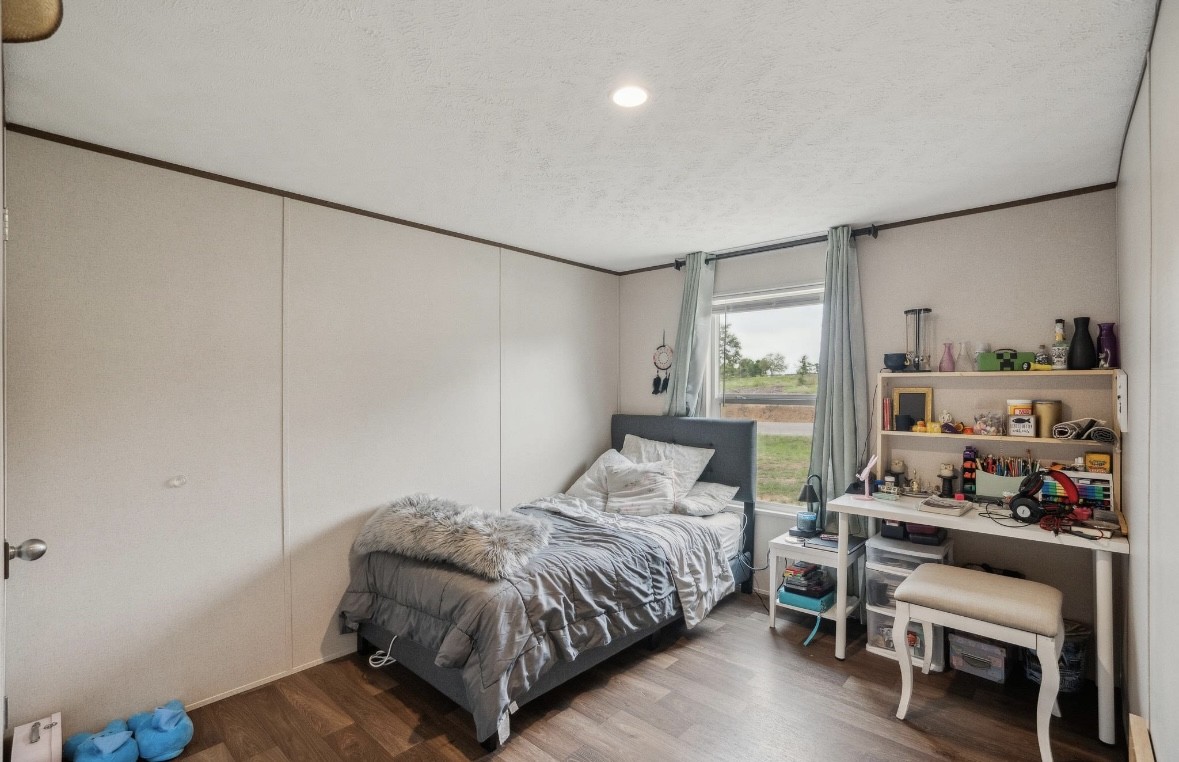 989 Ferguson Loop Dale Dale, TX 78616 - Photo 19 of 21 Bedroom with a textured ceiling, wood finished floors, and crown molding