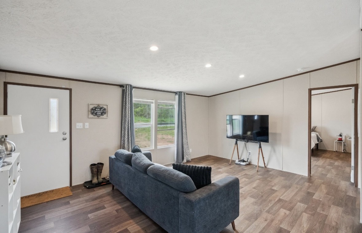 989 Ferguson Loop Dale Dale, TX 78616 - Photo 6 of 21 Living room with ornamental molding, dark wood finished floors, a textured ceiling, and recessed lighting