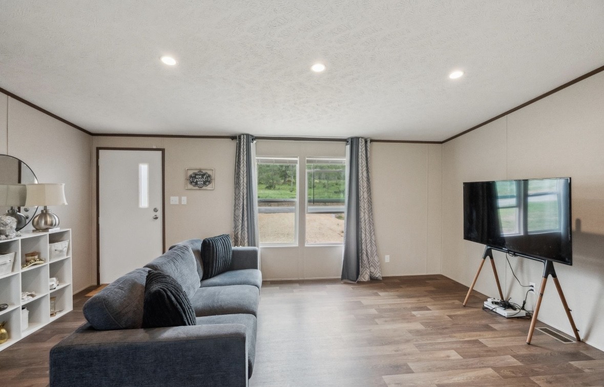 989 Ferguson Loop Dale Dale, TX 78616 - Photo 7 of 21 Living area with a textured ceiling, crown molding, wood finished floors, and recessed lighting