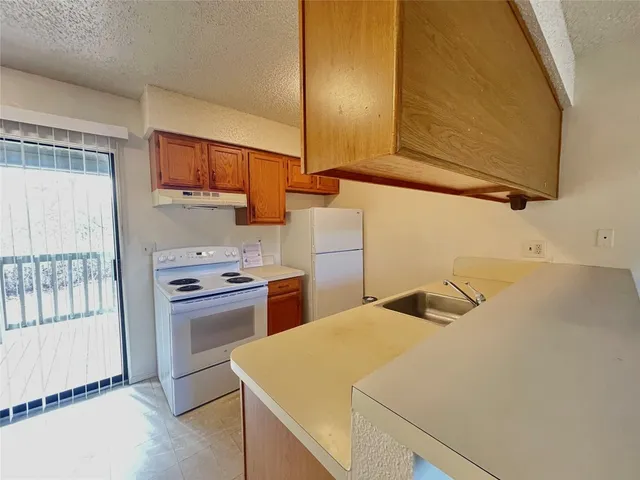 a kitchen with a stove a sink and a refrigerator
