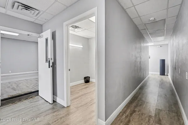 a view of a hallway with wooden floor and closet