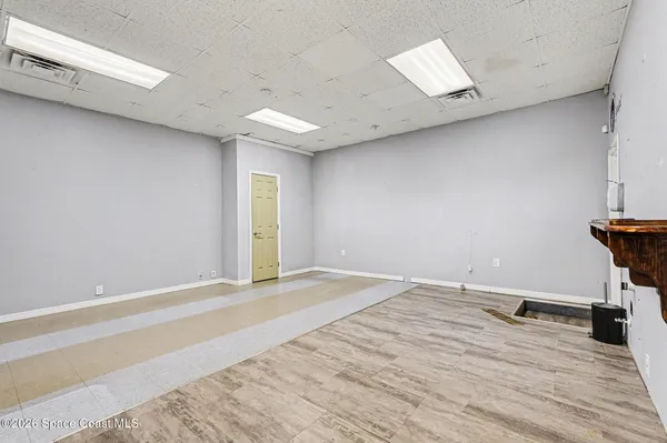 a view of empty room with wooden floor
