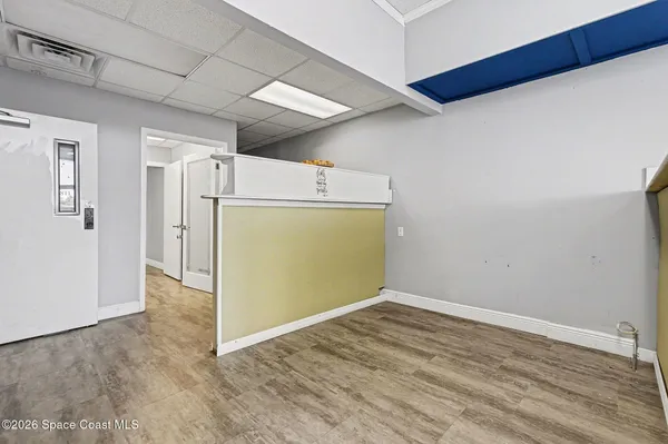 a view of empty room with wooden floor