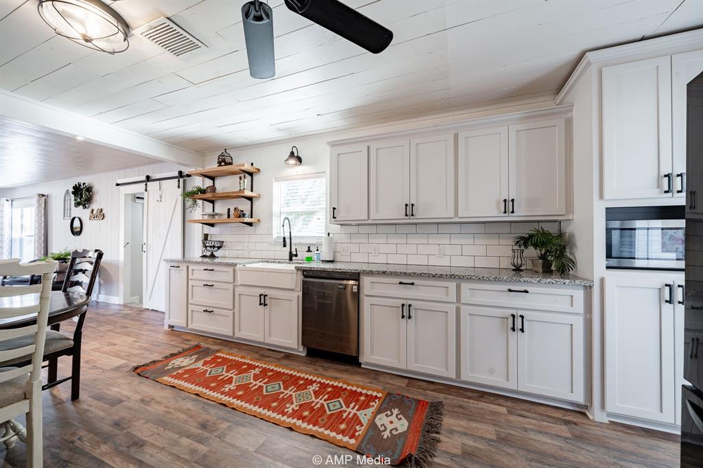 1002 Maple Street Stamford, TX 79553 - Photo 11 of 40 a kitchen with white cabinets and appliances