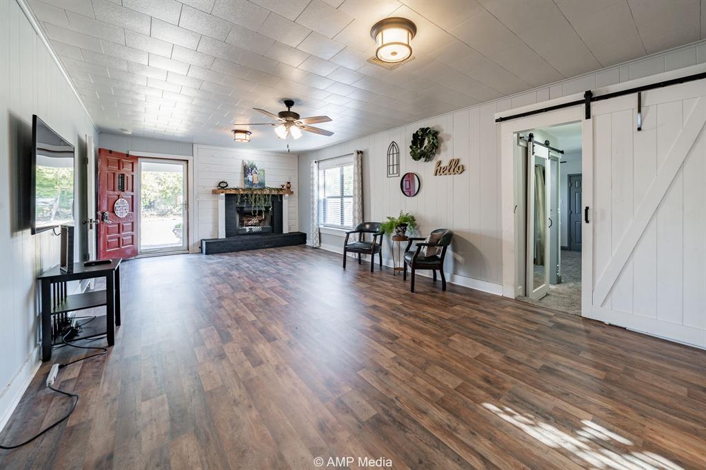 1002 Maple Street Stamford, TX 79553 - Photo 12 of 40 a view of a livingroom with furniture hardwood floor and a ceiling fan
