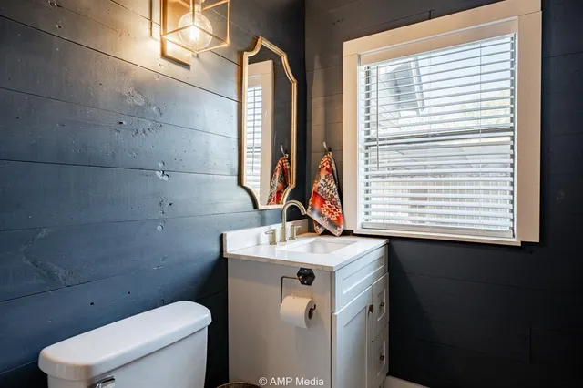 a bathroom with a sink toilet and window