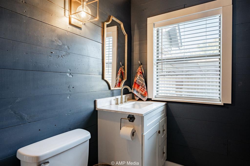 1002 Maple Street Stamford, TX 79553 - Photo 17 of 40 a bathroom with a sink toilet and window