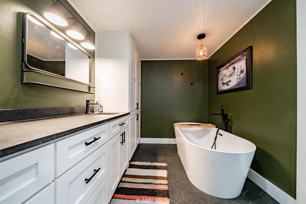 1002 Maple Street Stamford, TX 79553 - Photo 21 of 40 a bathroom with a bathtub and a sink