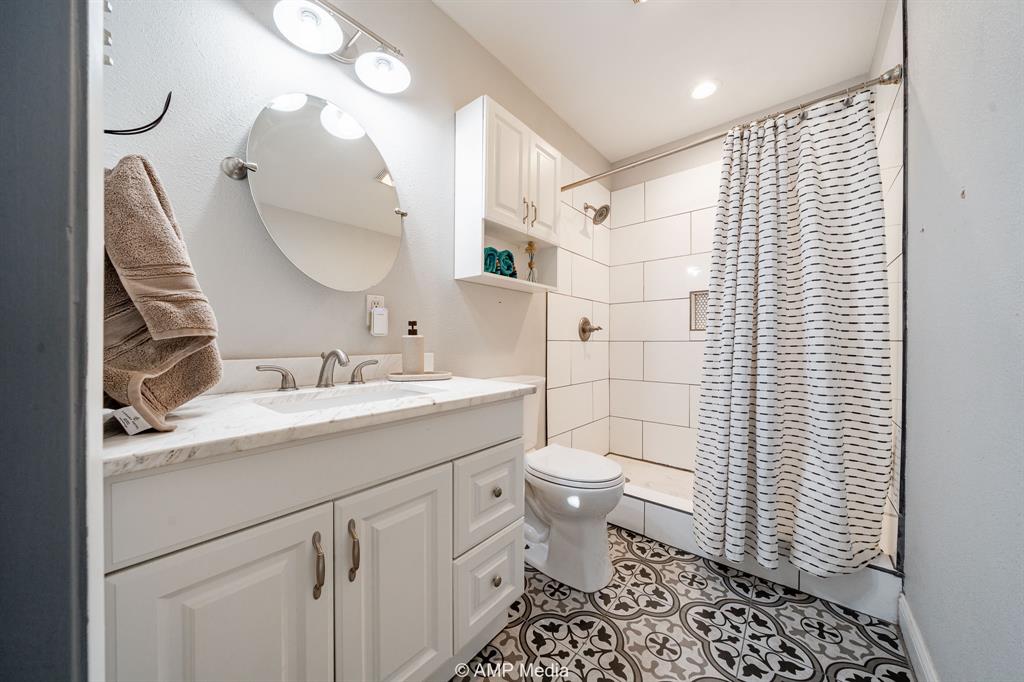 1002 Maple Street Stamford, TX 79553 - Photo 26 of 40 a bathroom with a sink toilet and shower