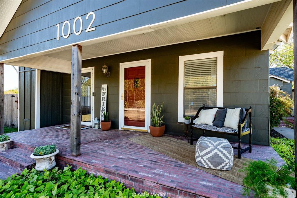 1002 Maple Street Stamford, TX 79553 - Photo 3 of 40 a view of a patio with table and chairs potted plants and floor to ceiling window
