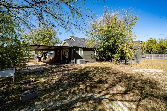 a view of a house with a tree next to a yard