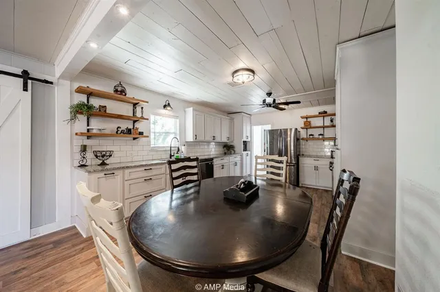 a kitchen with stainless steel appliances granite countertop a sink a refrigerator and wooden floor