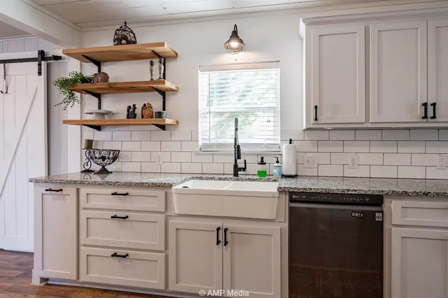 a kitchen with cabinets appliances a sink and a window