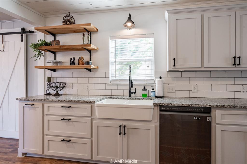 1002 Maple Street Stamford, TX 79553 - Photo 9 of 40 a kitchen with cabinets appliances a sink and a window