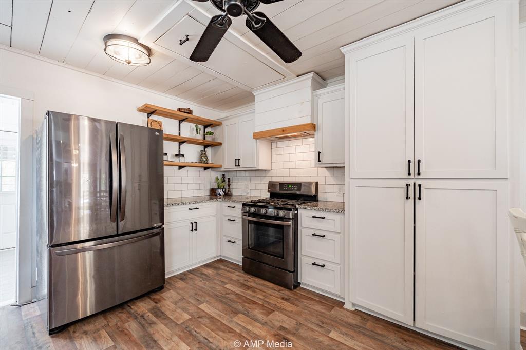 1002 Maple Street Stamford, TX 79553 - Photo 10 of 40 a kitchen with stainless steel appliances a refrigerator sink and cabinets