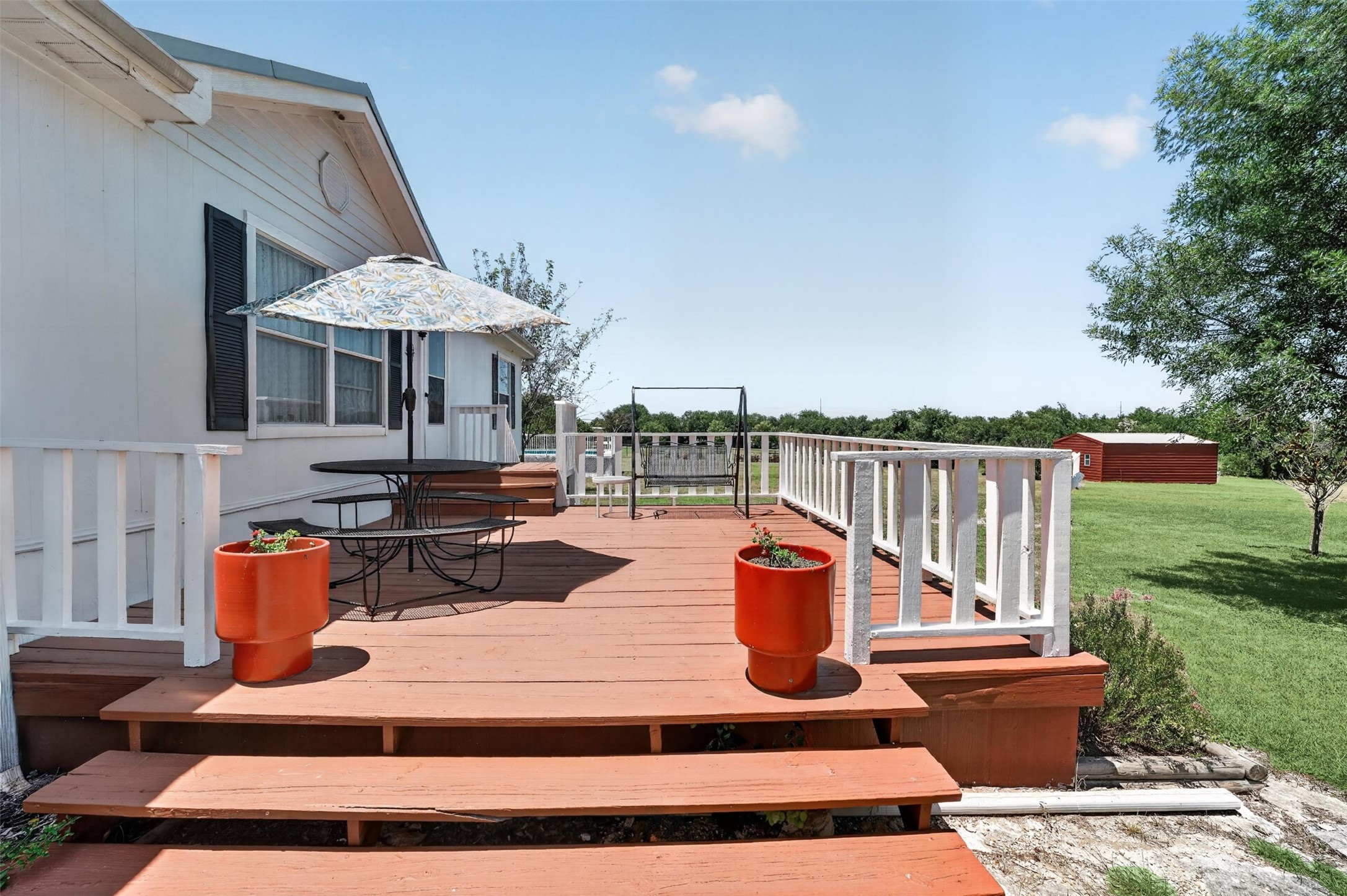 317 Rae Lane Jarrell, TX 76537 - Photo 24 of 40 A spacious wooden deck extends from the residence, offering a serene outdoor retreat with a scenic vista.