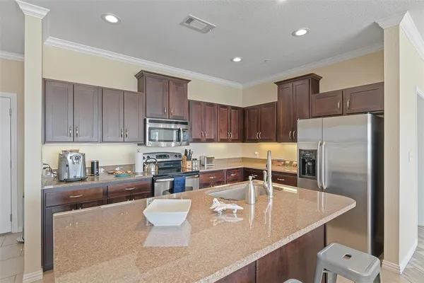 a kitchen with stainless steel appliances granite countertop a sink refrigerator and cabinets