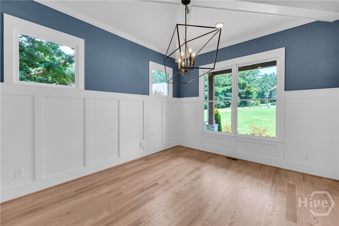 2476 St Martin Way Monroe, GA 30656 - Photo 7 of 75 Light wood-finish flooring complements the white board and batten wall treatment in the Dining Room