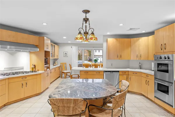 a kitchen with stainless steel appliances granite countertop a sink and a refrigerator