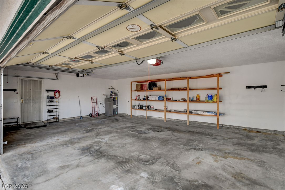 1401 Sharon Road Las Vegas, NV 89106 - Photo 62 of 73 An open garage features durable concrete flooring, wall shelving, and an automatic door opener.