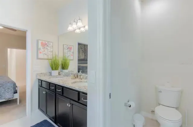 a spacious bathroom with a granite countertop sink a toilet and a mirror