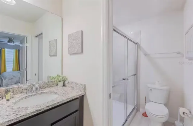 a bathroom with a granite countertop sink toilet and shower
