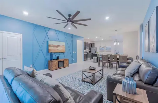 a living room with furniture and a view of kitchen