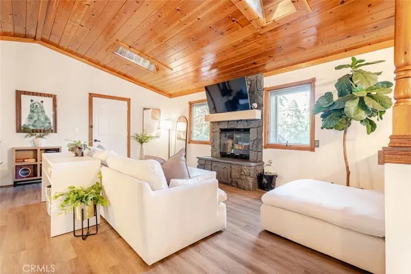 a living room with furniture a fireplace and a potted plant