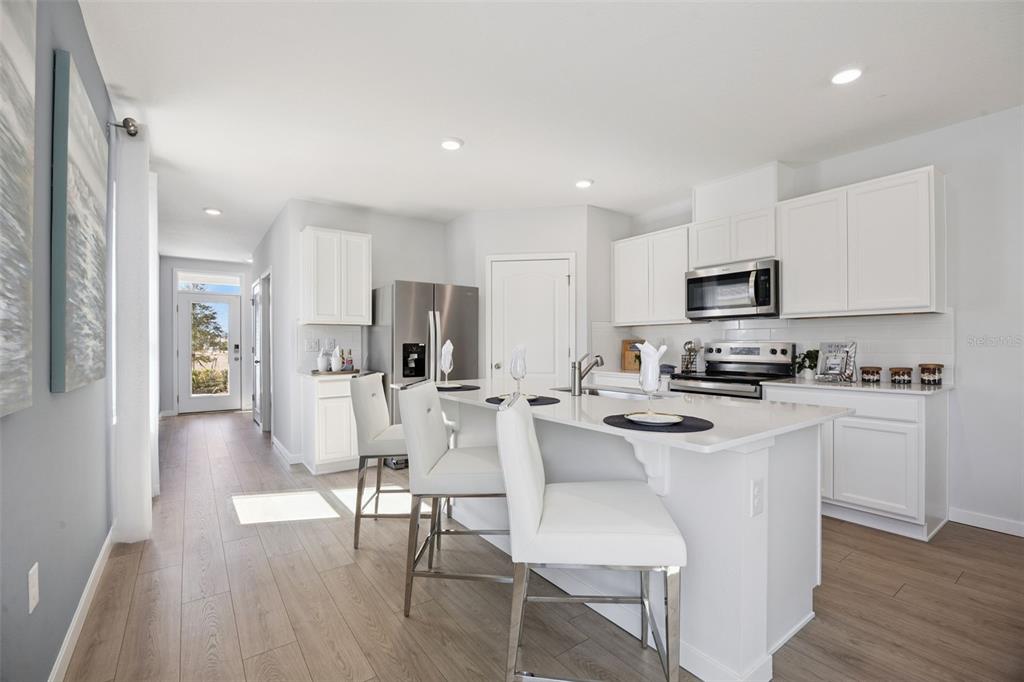 3019 House Finch Road St. Cloud, FL 34773 - Photo 7 of 54 a kitchen with white cabinets and stainless steel appliances