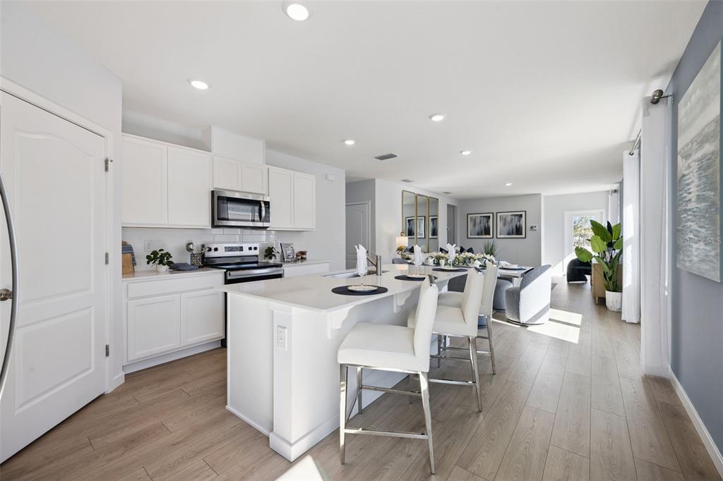 3019 House Finch Road St. Cloud, FL 34773 - Photo 8 of 54 a kitchen with white cabinets and stainless steel appliances
