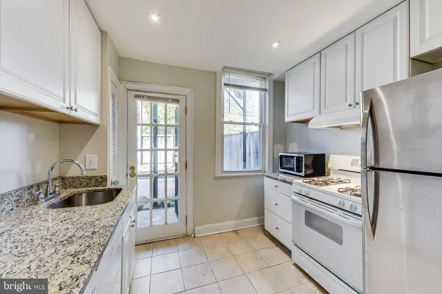 a kitchen with stainless steel appliances granite countertop a stove a sink and a refrigerator