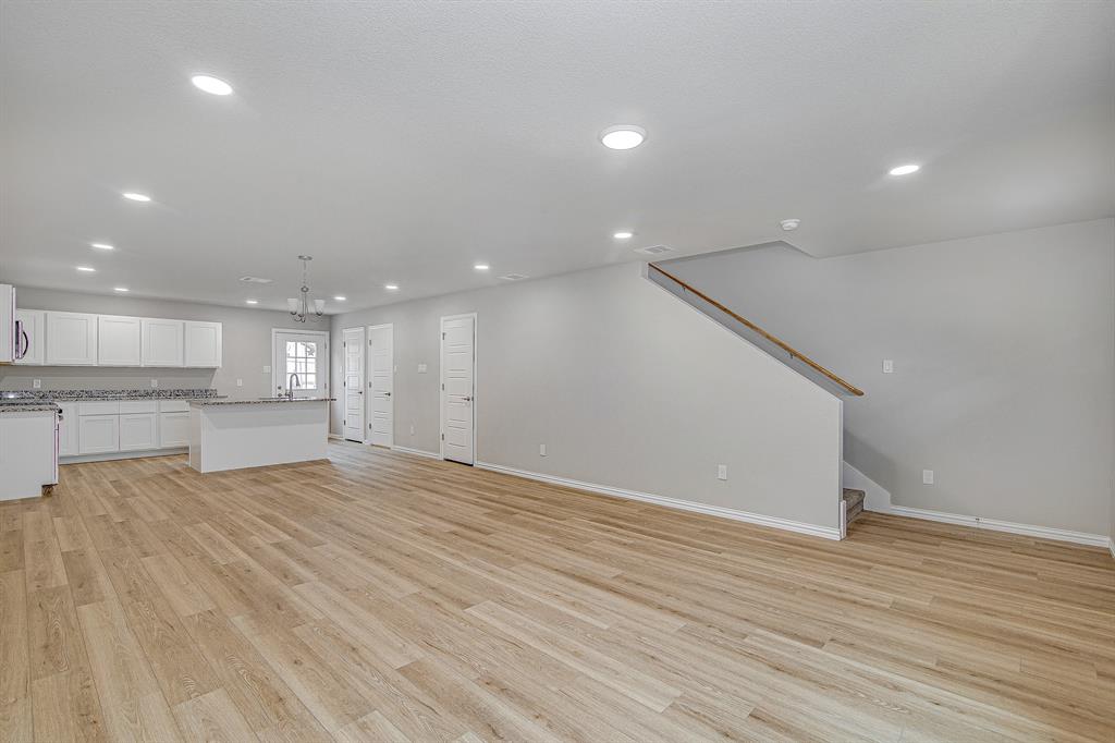 320 West Gambrell Street Fort Worth, TX 76115 - Photo 4 of 40 a view of an empty room with wooden floor and kitchen