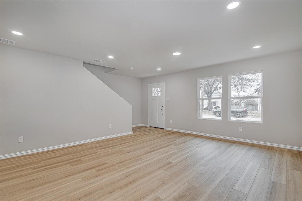 320 West Gambrell Street Fort Worth, TX 76115 - Photo 5 of 40 an empty room with wooden floor and windows