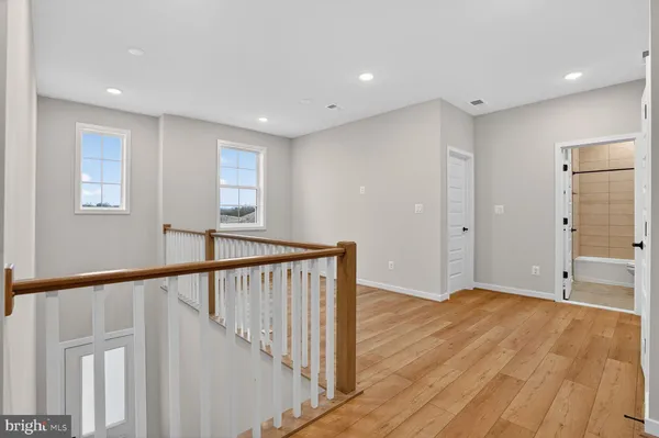a view of a hallway with wooden floor and staircase