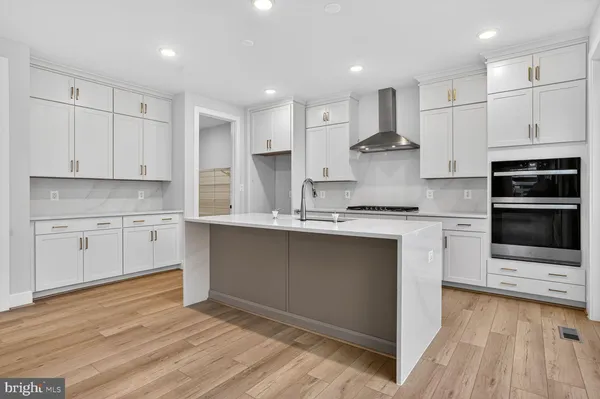 a kitchen with stainless steel appliances granite countertop a stove a sink and white cabinets