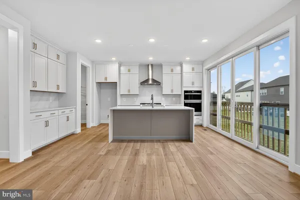 a large kitchen with stainless steel appliances granite countertop a large counter top a stove and a refrigerator