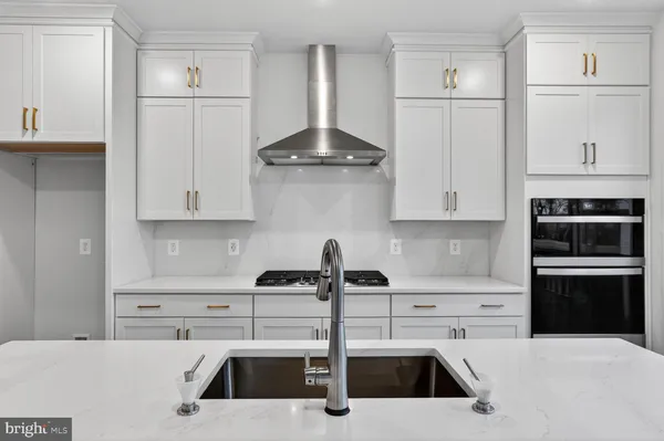 a kitchen with stainless steel appliances a sink a stove and a refrigerator