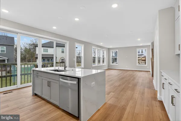 a large kitchen with stainless steel appliances granite countertop a lot of counter space and wooden floors