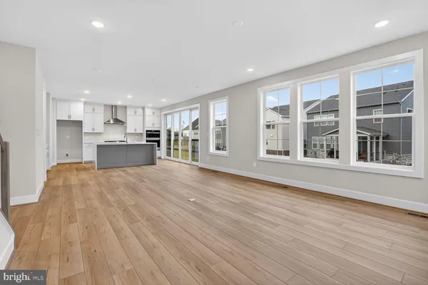 a view of empty room with wooden floor and windows