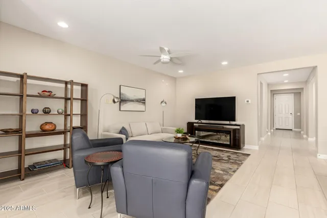 a living room with furniture a flat screen tv and kitchen view