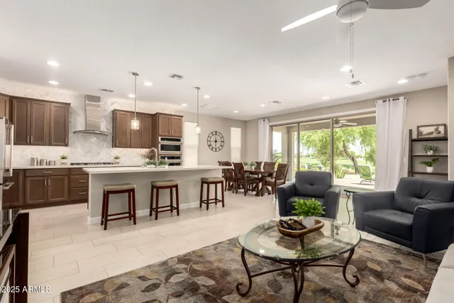 a living room with stainless steel appliances kitchen island granite countertop furniture and a large window