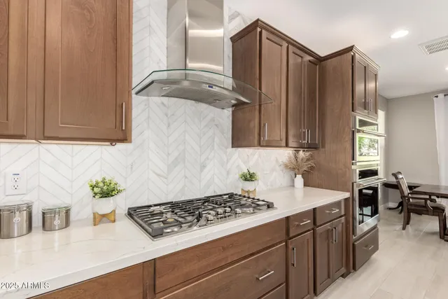 a kitchen with stainless steel appliances a stove a sink and cabinets