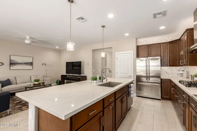 a kitchen with stainless steel appliances granite countertop a sink a stove and a refrigerator