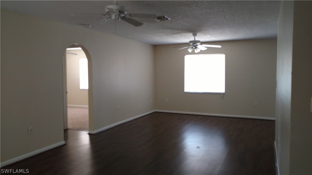 7550 Garry Road Fort Myers, FL 33967 - Photo 4 of 23 an empty room with wooden floor and windows