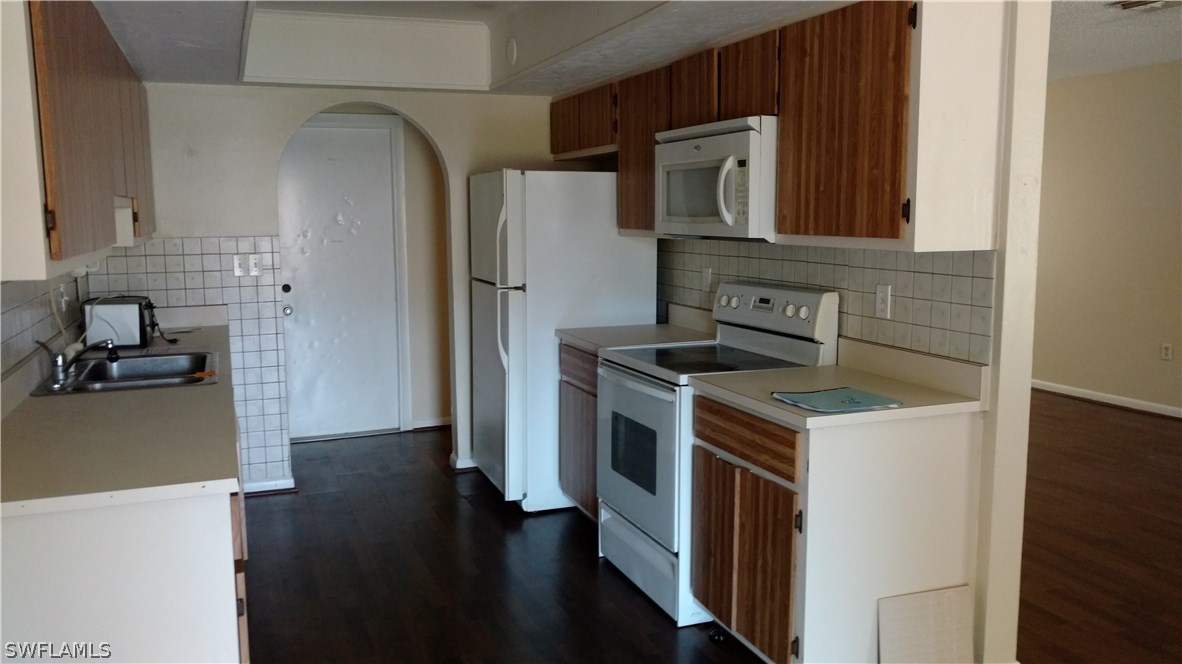7550 Garry Road Fort Myers, FL 33967 - Photo 8 of 23 a kitchen with a stove and a refrigerator